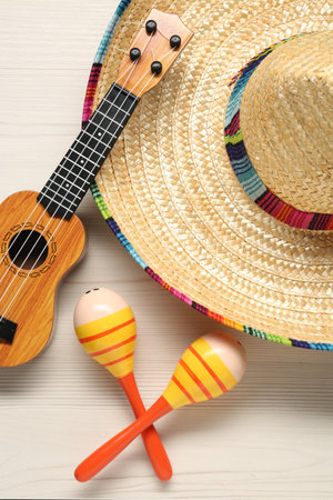 Mexican sombrero hat, maracas and guitar on white wooden background, flat layの写真素材