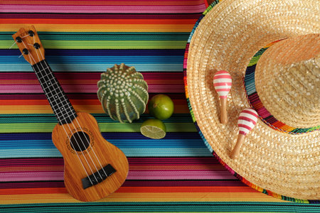 Flat lay composition with Mexican sombrero hat and ukulele on color tableの写真素材