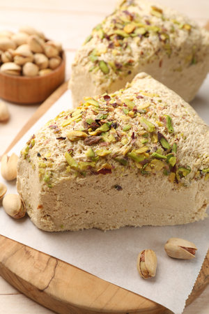 Tasty halva with pistachios on table, closeup