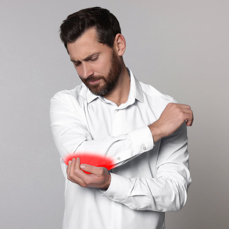 Man suffering from rheumatism on light backgroundの写真素材