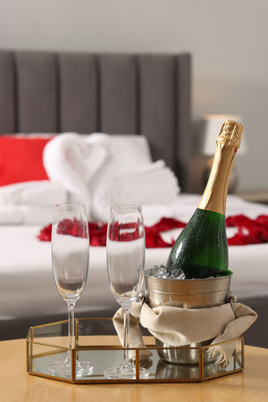 Honeymoon. Sparkling wine and glasses on wooden table in roomの写真素材