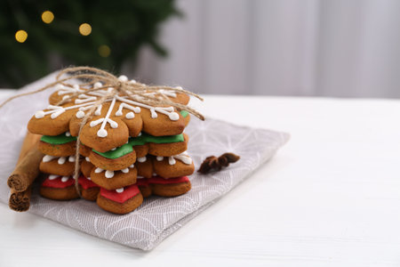 Decorated cookies on white table against blurred Christmas lights, closeup. Space for textの写真素材