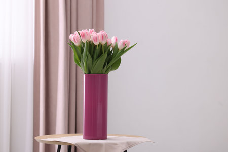 Beautiful bouquet of fresh pink tulips on table indoors. Space for textの写真素材
