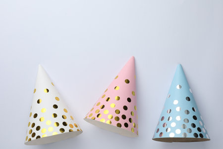 Beautiful party hats on light background, top view. Space for textの写真素材