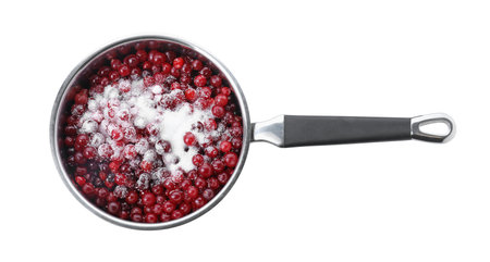 Making cranberry sauce. Fresh cranberries with sugar in saucepan isolated on white, top viewの写真素材