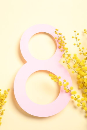 8 March greeting card design with mimosa flowers on light yellow background, top viewの写真素材