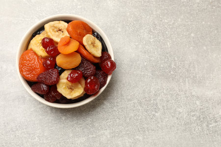 Mix of delicious dried fruits on gray table, top view. Space for textの写真素材