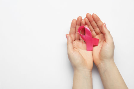 Breast cancer awareness. Woman with pink ribbon on white background, top view. Space for textの写真素材