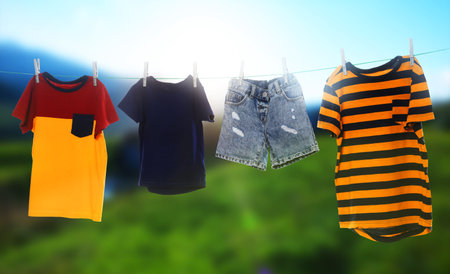 Different clothes drying on washing line outdoors, banner designの写真素材