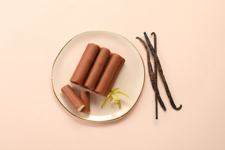 Glazed curd cheese bars, vanilla pods and flower on light pink background, top viewの写真素材