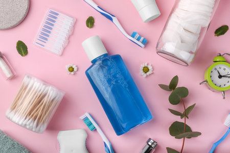 Flat lay composition with fresh mouthwash in bottle and personal care products on pink background. Daily routineの写真素材