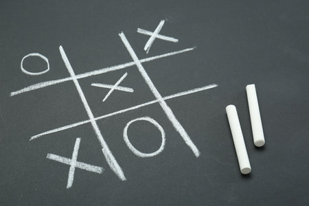 Tic tac toe game drawn on chalkboardの写真素材