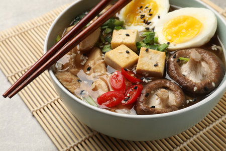Bowl of delicious ramen and chopsticks on gray table, closeup. Noodle soupの写真素材