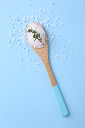 Salt and thyme in spoon on light blue background, top viewの写真素材