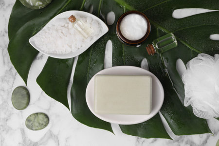Flat lay composition with different spa products and tropical leaf on white marble tableの写真素材