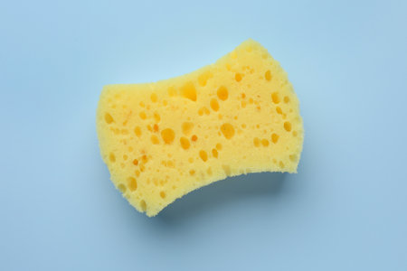 New yellow sponge on light blue background, top viewの写真素材