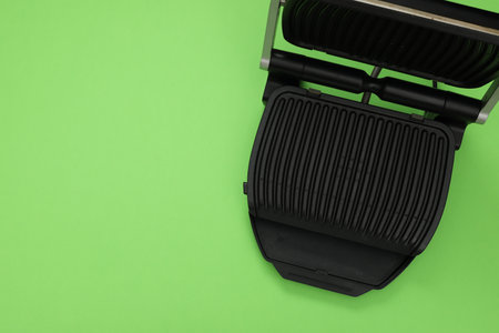 Electric grill on green background, top view. Space for text. Cooking applianceの写真素材