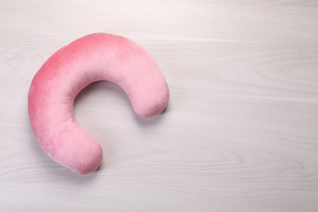 Pink travel pillow on white wooden table, top view. Space for textの写真素材