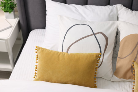 Soft pillows and duvet on bed at home