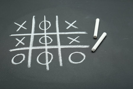 Tic tac toe game drawn on chalkboardの写真素材