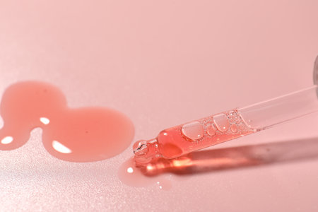 Pipette and moisturizing serum on pink background, closeupの写真素材