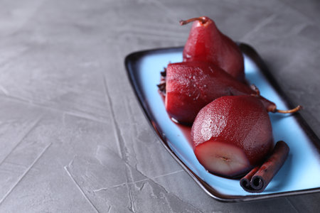 Tasty red wine poached pears and spices on gray table, closeup. Space for textの写真素材