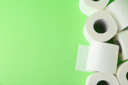 Soft toilet paper rolls on green background, flat lay. Space for textの写真素材
