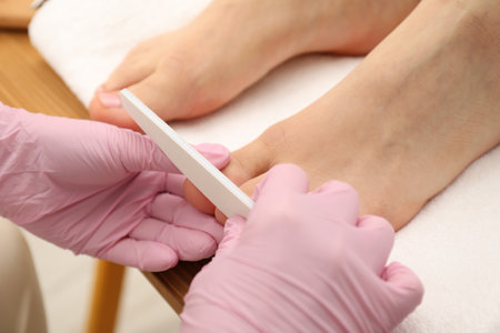 Professional pedicurist filing client`s toenails in beauty salon, closeupの写真素材
