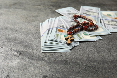 Wooden cross and money on gray table, closeup. Space for textの写真素材