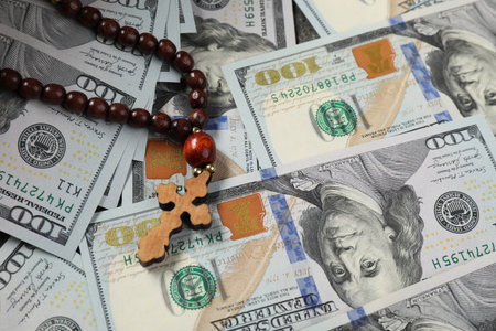 Wooden cross on dollar banknotes, closeup viewの写真素材
