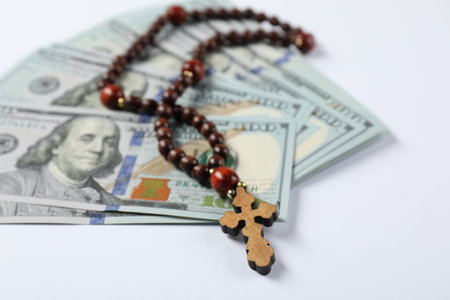 Wooden cross and money on white background, closeupの写真素材