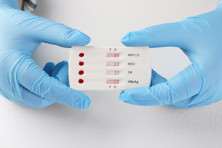 Doctor holding disposable multi-infection express test at white table, closeupの写真素材
