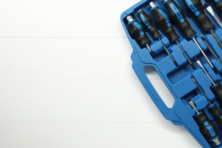 Set of screwdrivers in open toolbox on white wooden table, top view. Space for textの写真素材