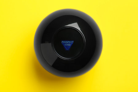 Magic eight ball with prediction Prospect Good on yellow background, top view