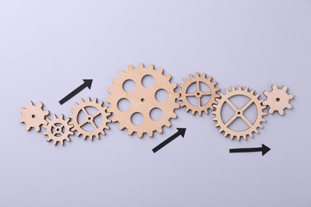 Business process organization and optimization. Scheme with wooden figures and arrows on lilac...
