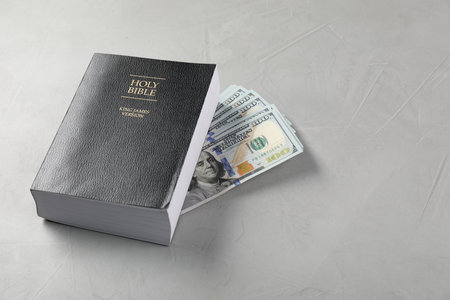 Holy Bible and money on gray table. Space for textの写真素材