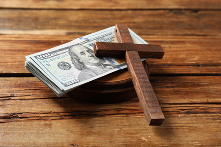 Cross and money on wooden table, closeupの写真素材