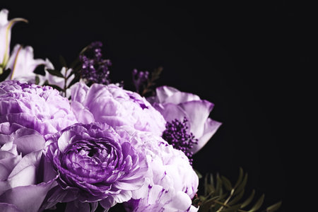 Bouquet with violet flowers on black background, closeup. Funeral attributesの写真素材