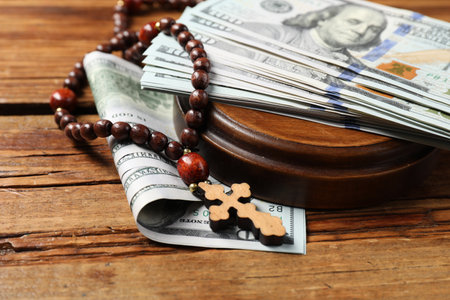 Cross and money on wooden table, closeupの写真素材