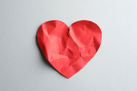 Crumpled red paper heart on white background, top view. Broken heartの写真素材