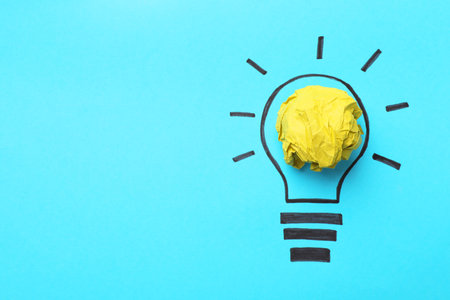 Idea concept. Light bulb made with crumpled paper and drawing on light blue background, top view. Space for textの写真素材