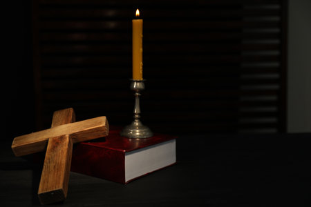 Church candle, Bible and wooden cross on table, space for textの写真素材