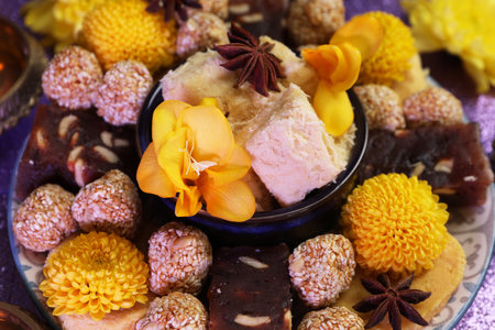 Diwali celebration. Tasty Indian sweets and flowers on tableの写真素材