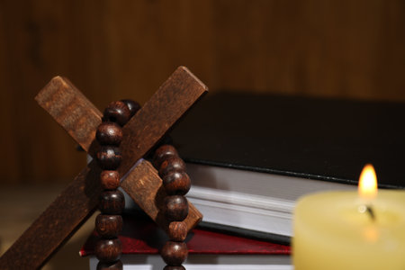 Bible, wooden cross, rosary beads and church candle on table, closeupの写真素材