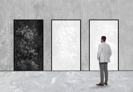 Man standing in front of drawn doorsの写真素材