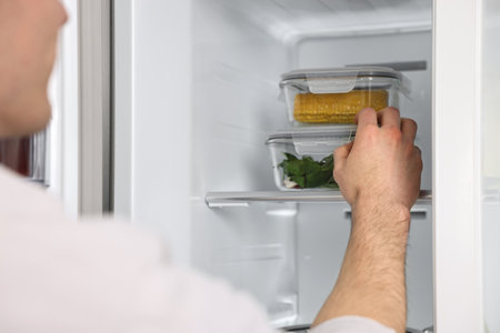 Man taking containers with vegetables out of refrigerator, closeupの写真素材