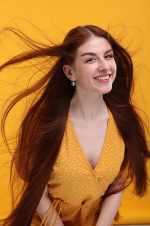 Portrait of smiling woman on yellow backgroundの写真素材