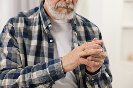 Arthritis symptoms. Man suffering from pain in fingers at home, closeupの写真素材