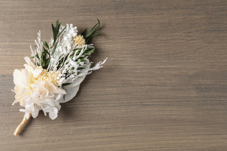 Beautiful boutonniere on wooden background, top view. Space for text