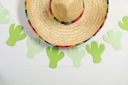 Mexican sombrero hat and garland on white wooden backgroundの写真素材